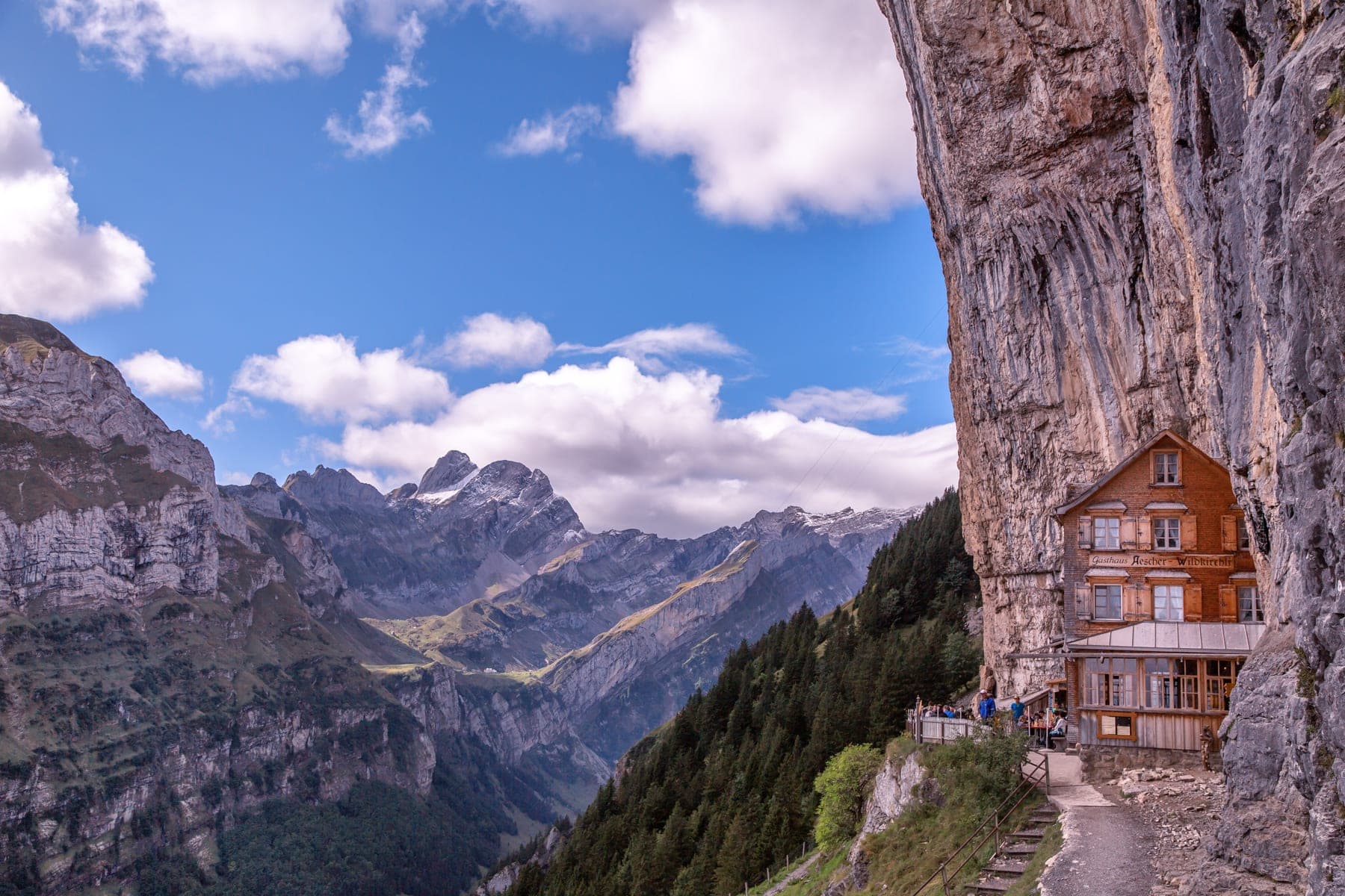 Berggasthaus Äscher-Wildkirchli unter der Felswand der Ebenalp mit Blick in den Alpstein, Appenzell Innerrhoden