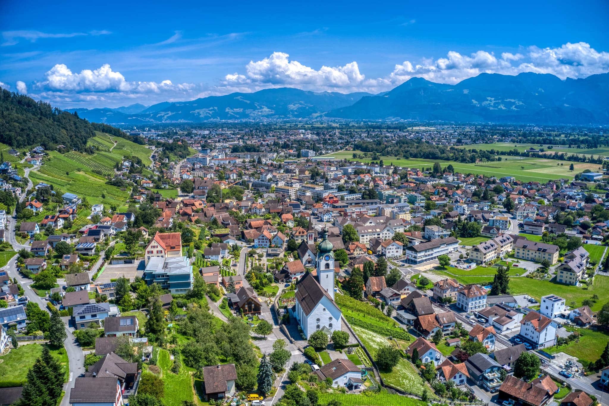 Balgach mit Kirche am Hang und Blick über das Rheintal