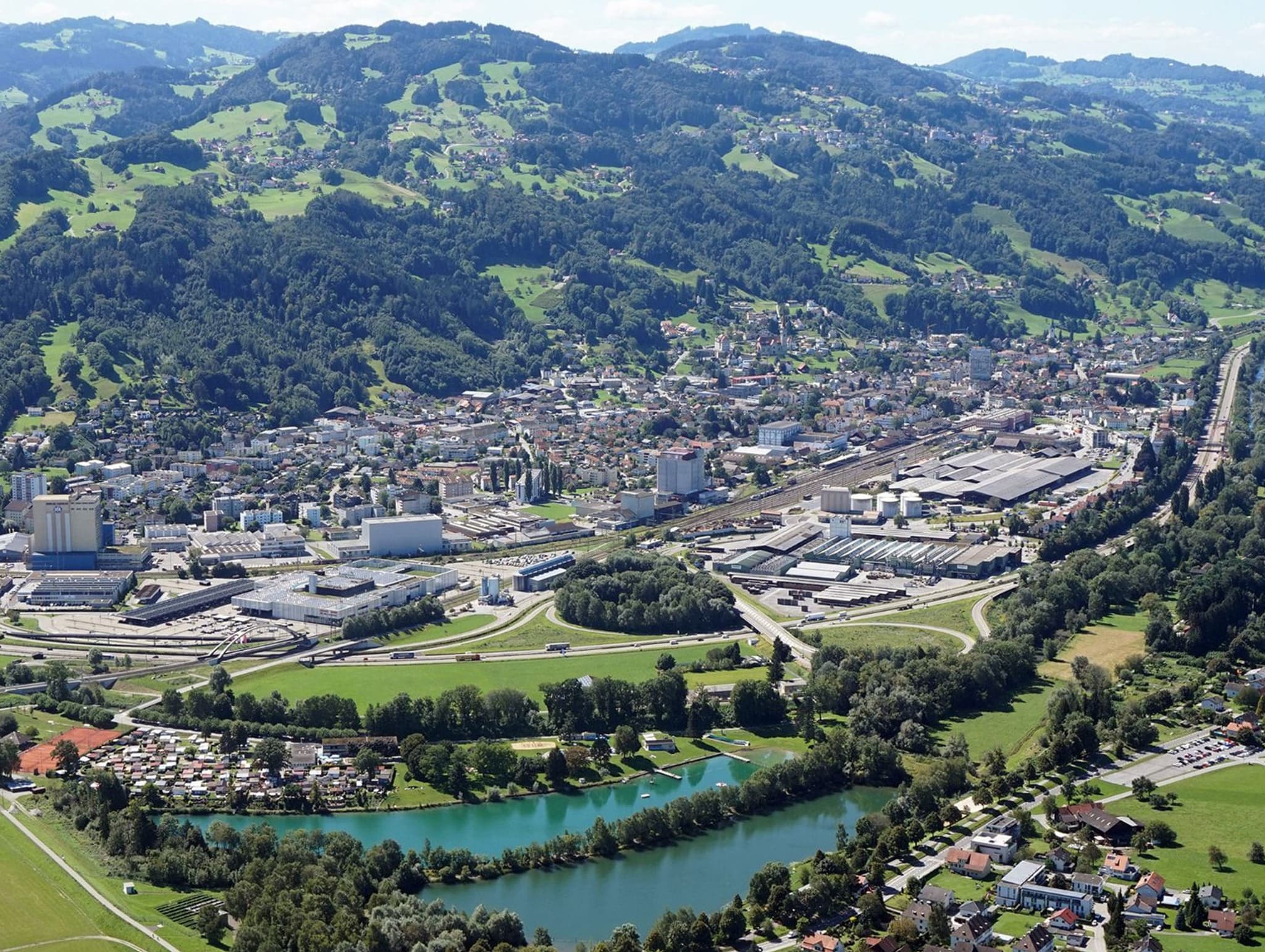 St. Margrethen aus der Luft – Bahnhofsquartier, Gewerbe und Hanglagen über dem Rheintal
